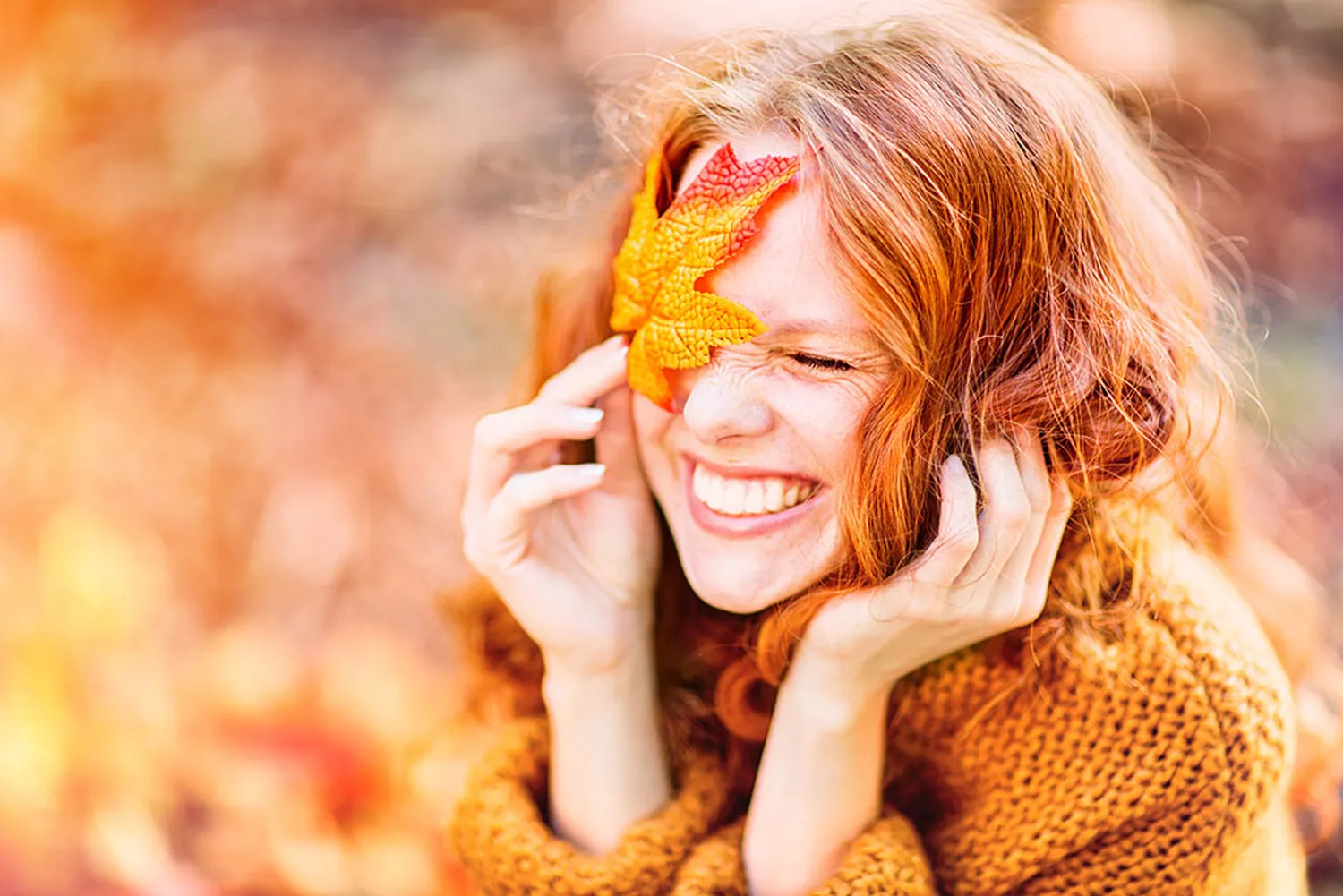 Living Seminar Point, Eine lächelnde Frau, die ein Herbstblatt an ihr Auge hält